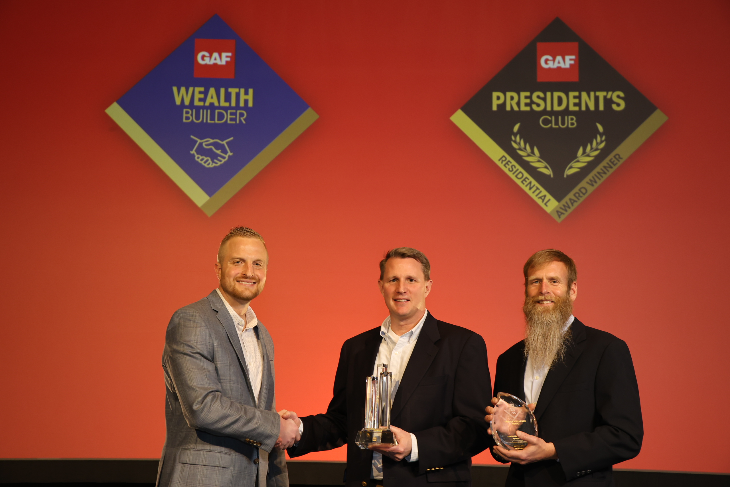 GAF's Tyler Miler presents the 2022 3 Star President's Club Award to Elite Roof and Solar Co-owners Mick Koster and Ross Erickson