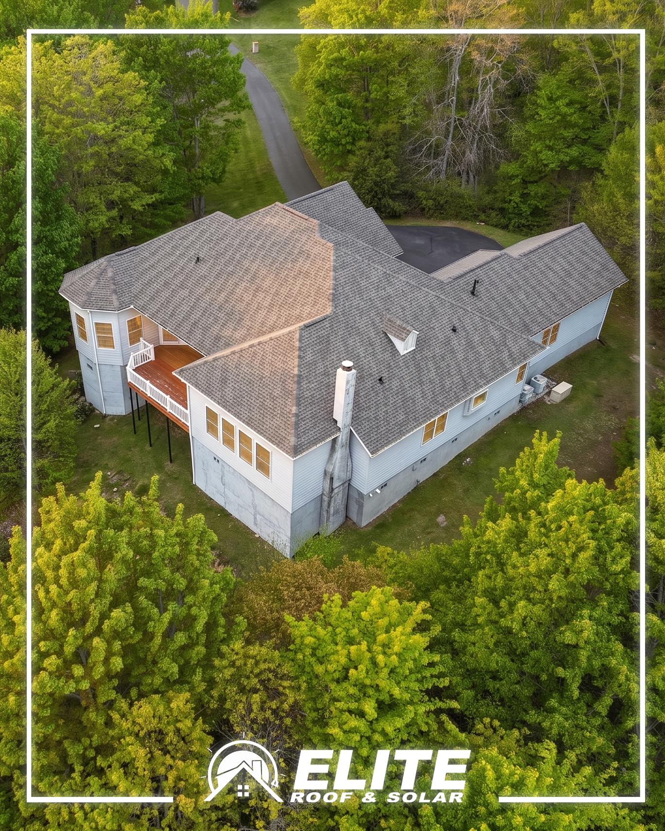 Aerial view of a gray shingle roof surrounded by tall trees, a key area to check for storm preparedness